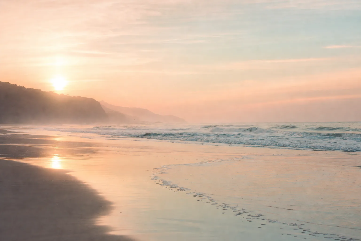 Pastel sunlight across a calm shoreline